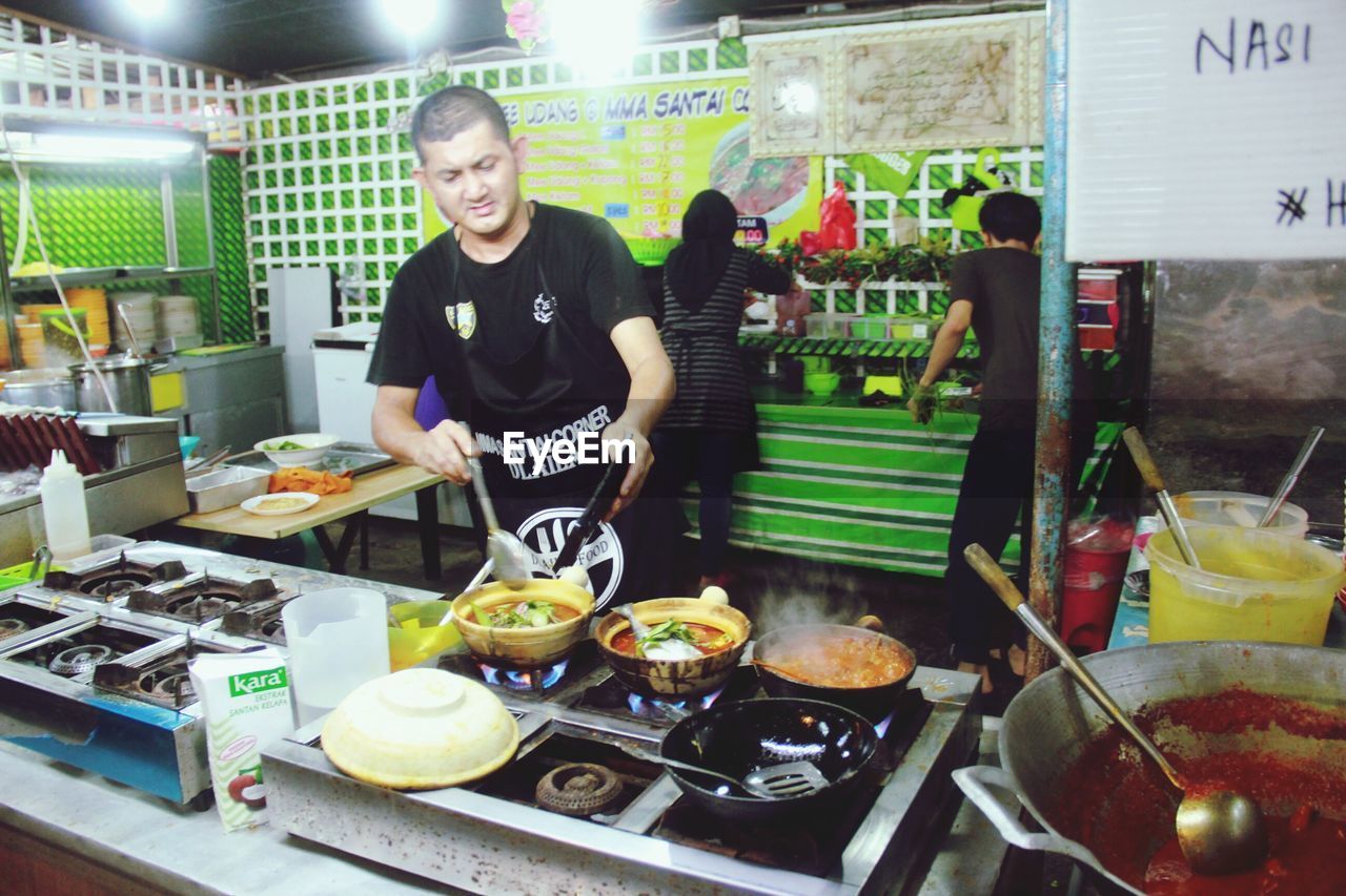 FULL LENGTH OF A MAN PREPARING FOOD IN KITCHEN