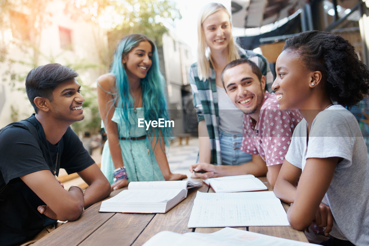 Cheerful friends studying at campus