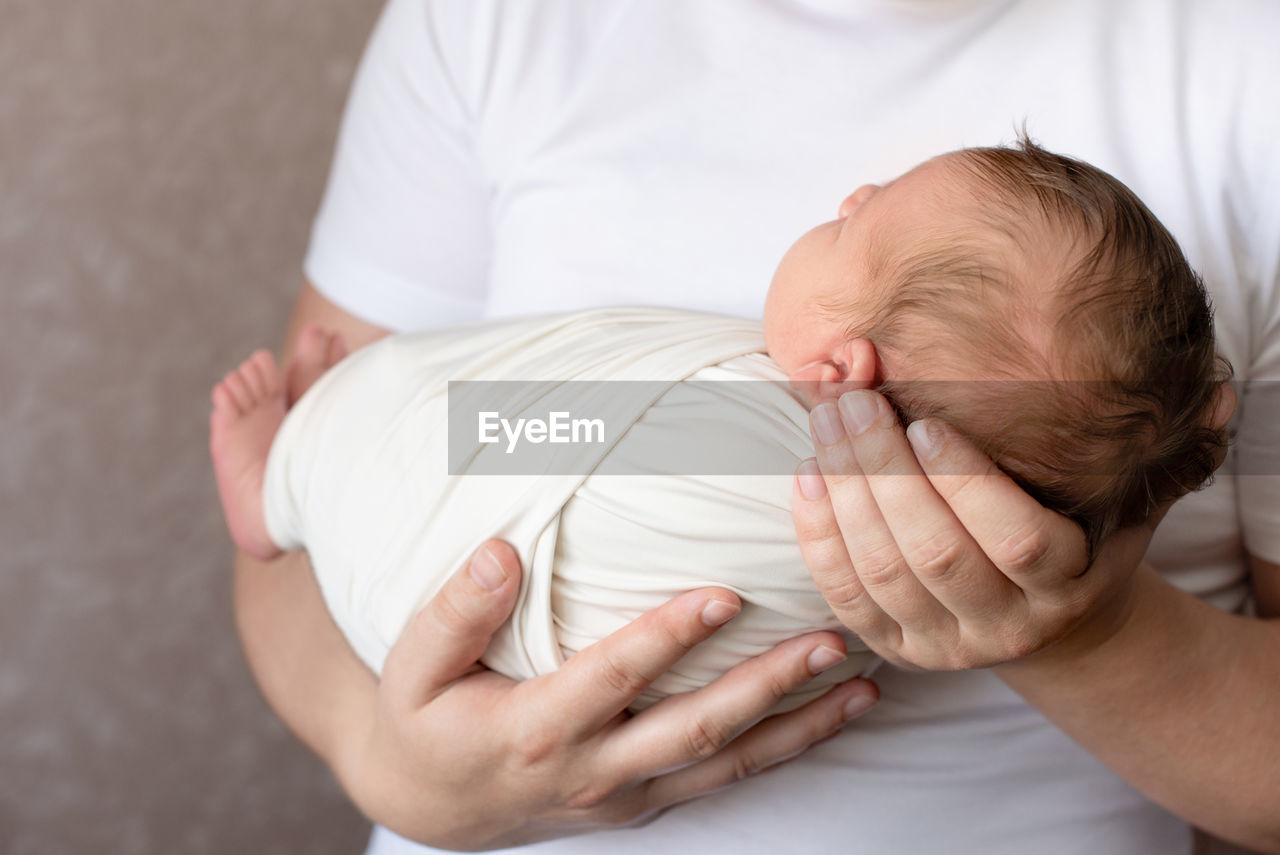 Midsection of mother holding baby