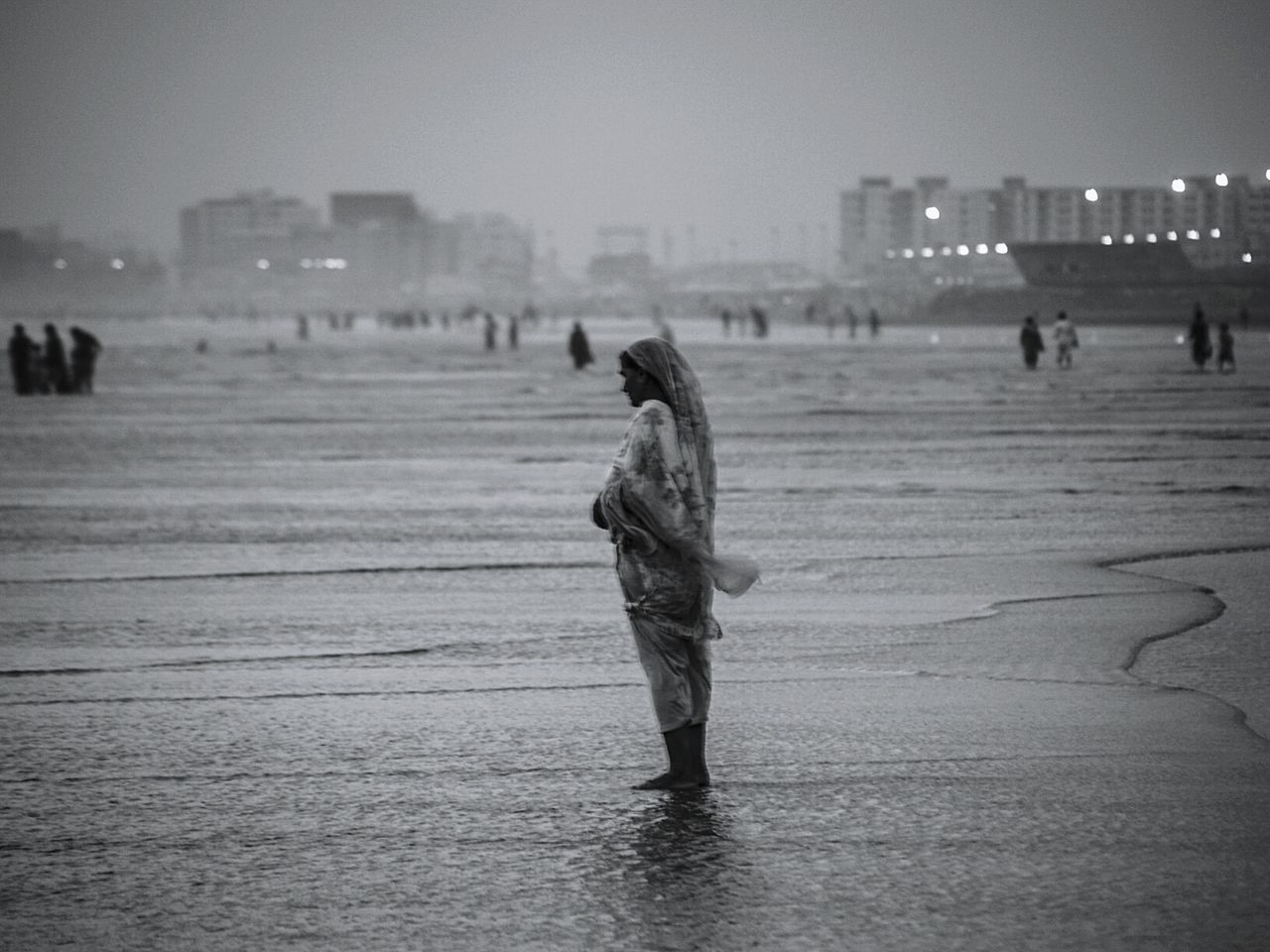 Woman standing on beach at sunset