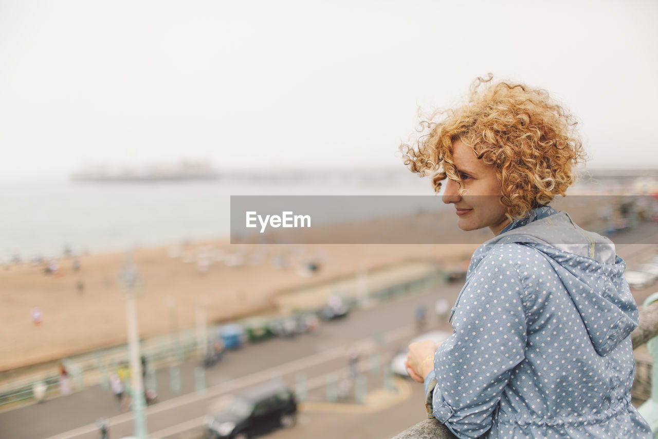 Woman looking at sea against clear sky