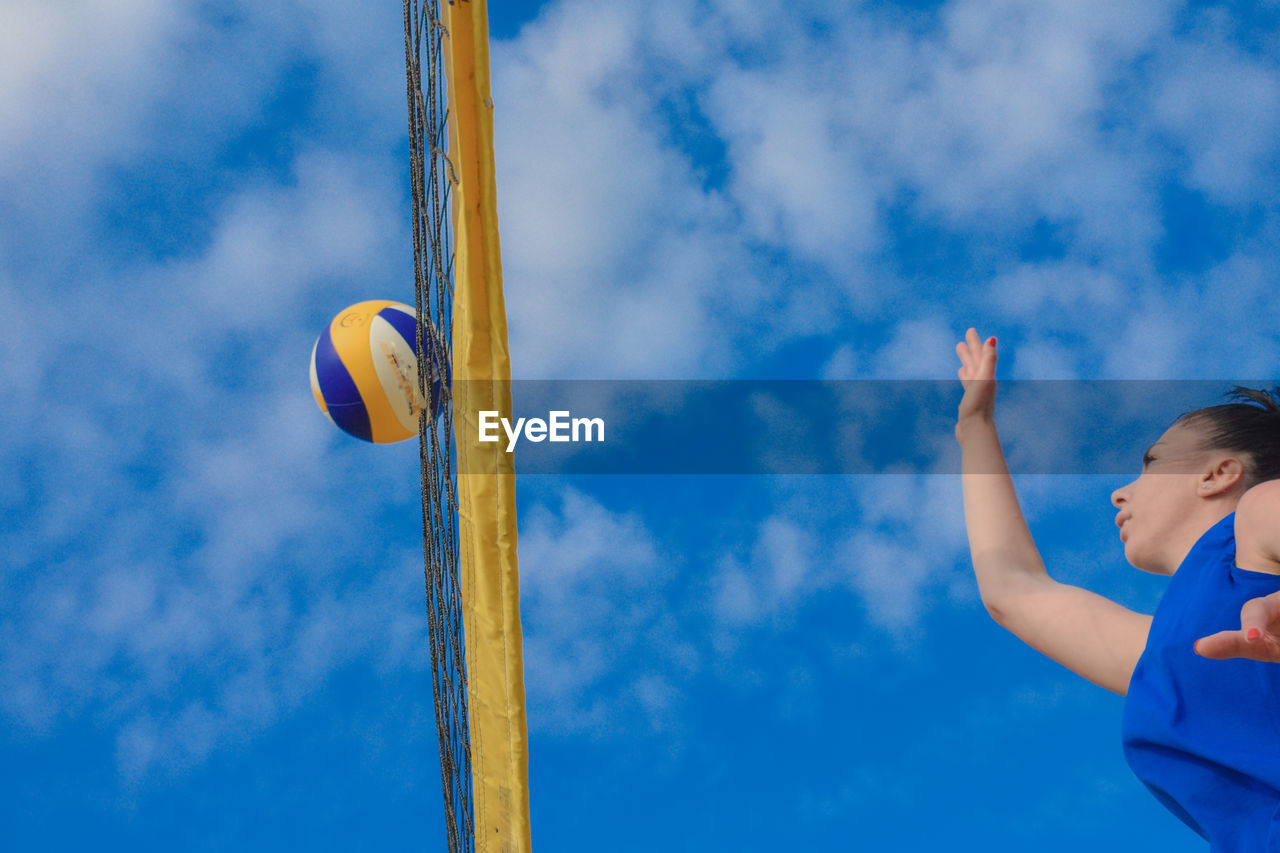 Low angle view of woman playing volleyball