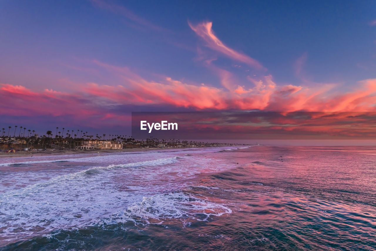 View over the ocean of the coastline with a red sunset