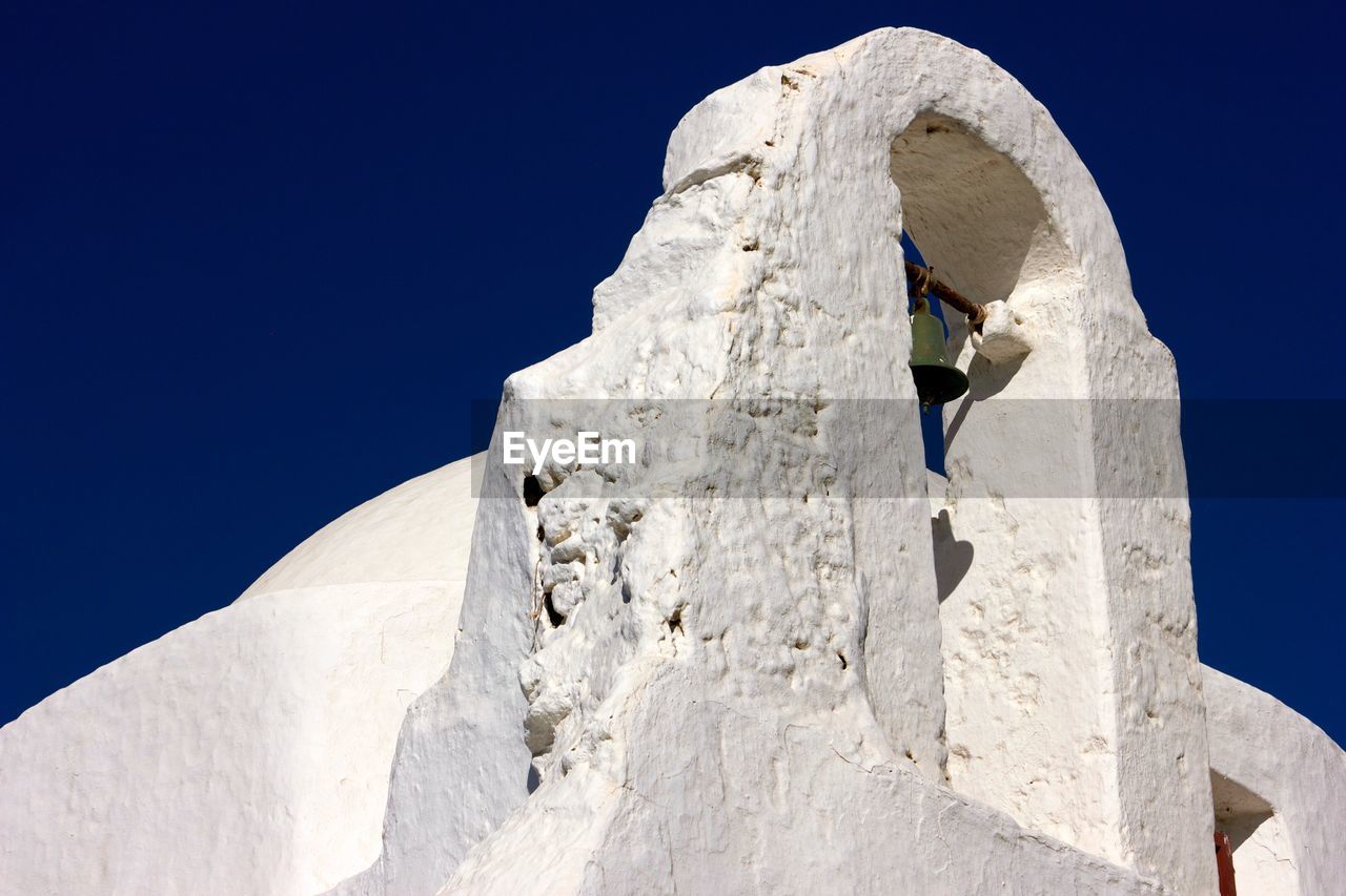 Low angle view of bell tower against clear blue sky