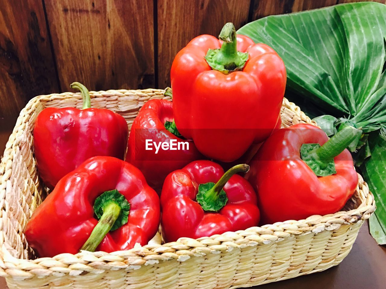 HIGH ANGLE VIEW OF RED BELL PEPPERS IN WICKER BASKET