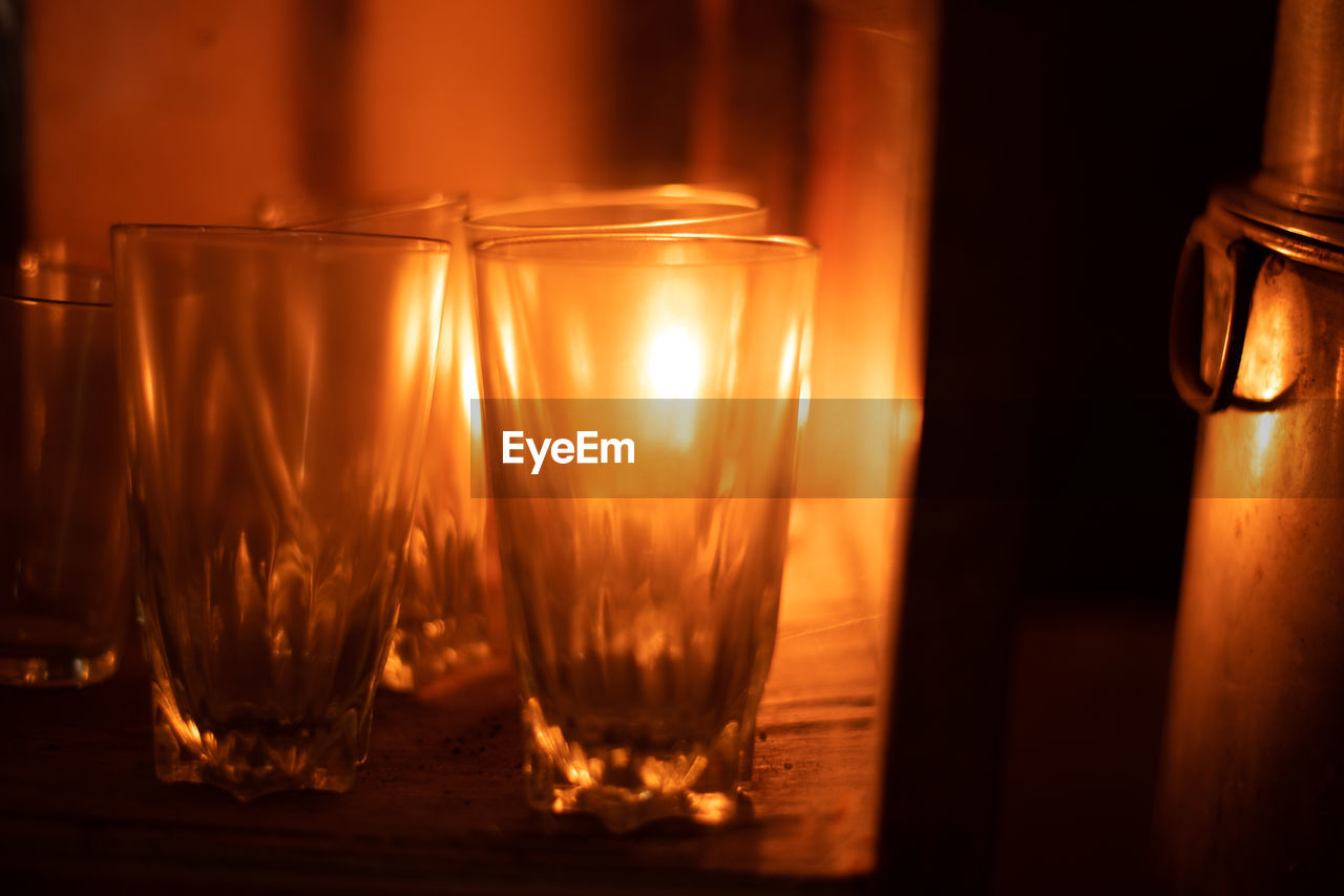 CLOSE-UP OF WINE GLASS WITH CANDLES ON TABLE