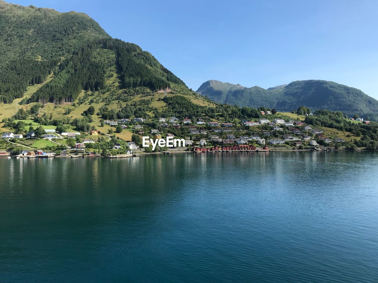 Scenic view of townscape by sea against sky