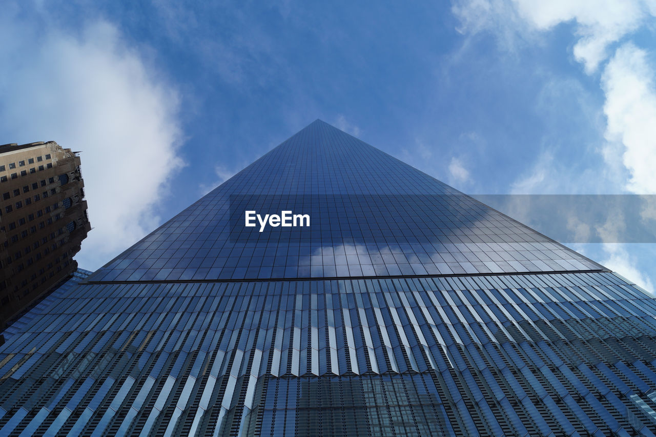 Low angle view of modern building against cloudy sky