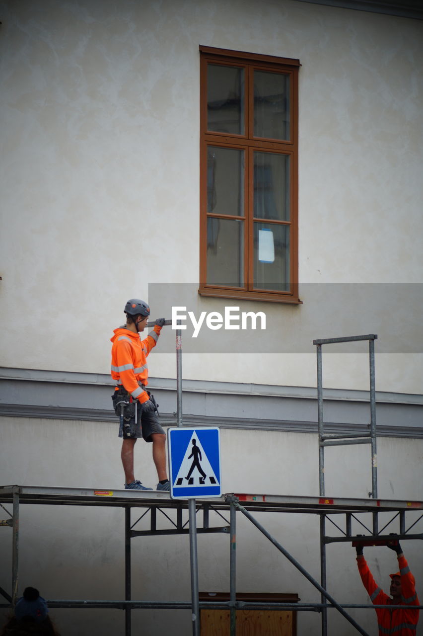 Low angle view of mature man standing against building