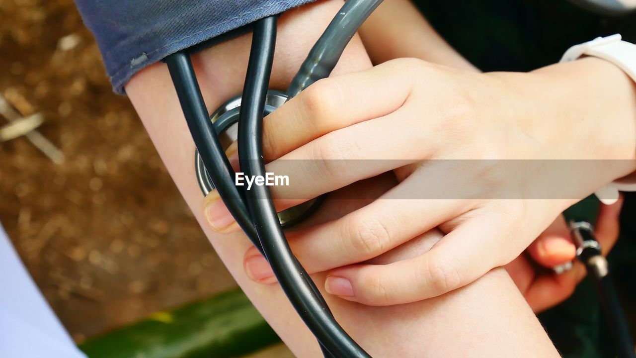 Midsection of woman checking blood pressure