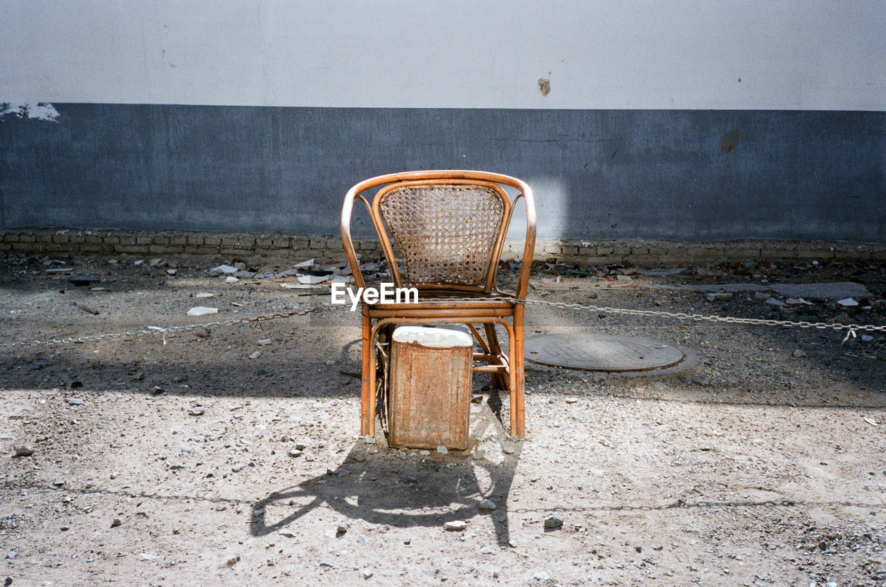 High angle view of abandoned chair against wall