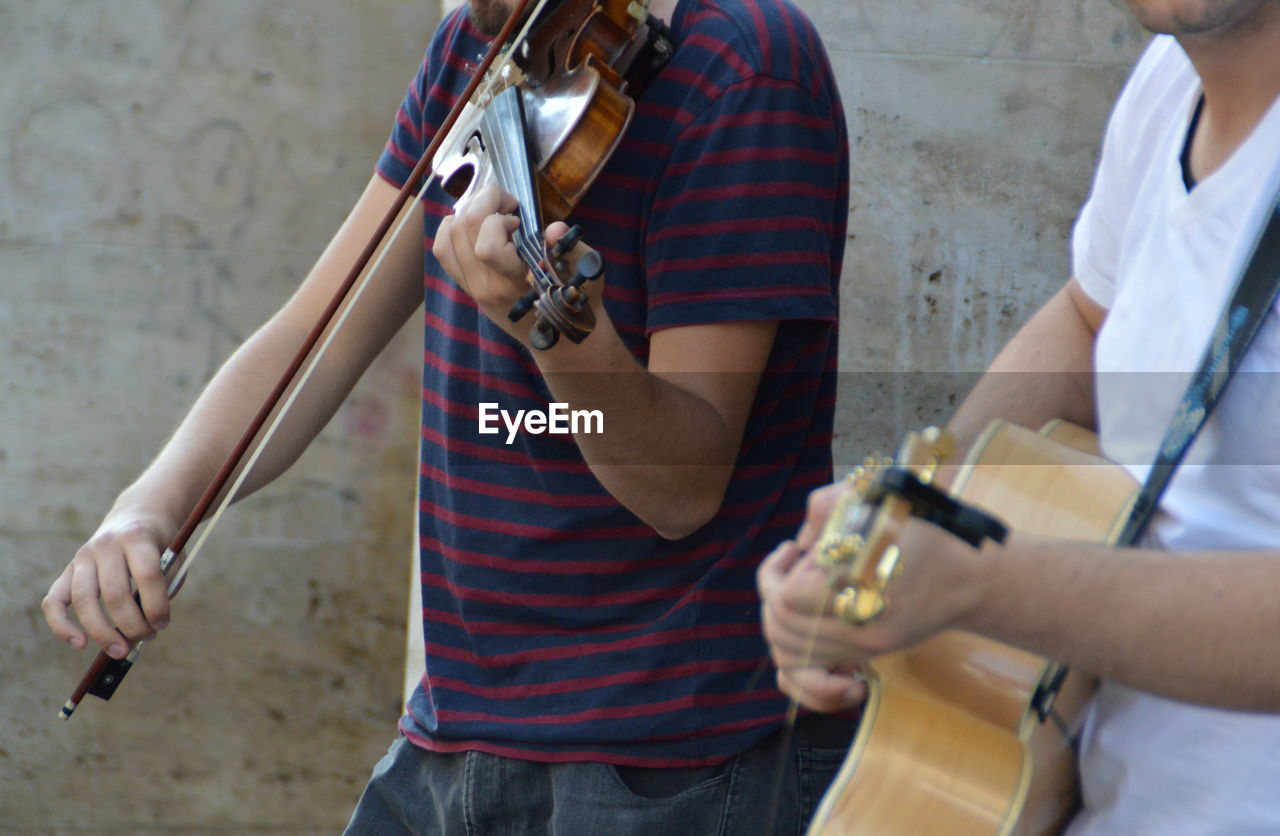 Midsection of performers playing musical equipment