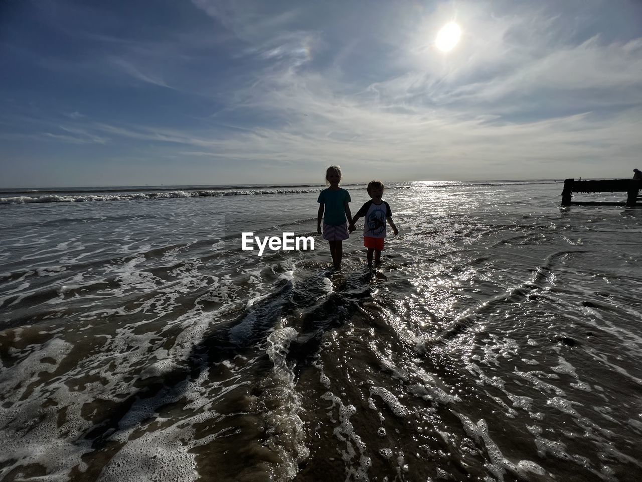 rear view of man walking on beach against sky