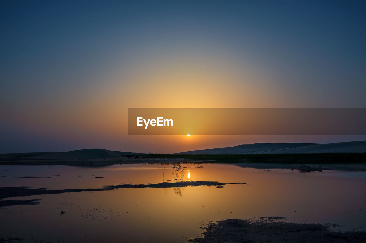 Scenic view of lake against sky during sunset