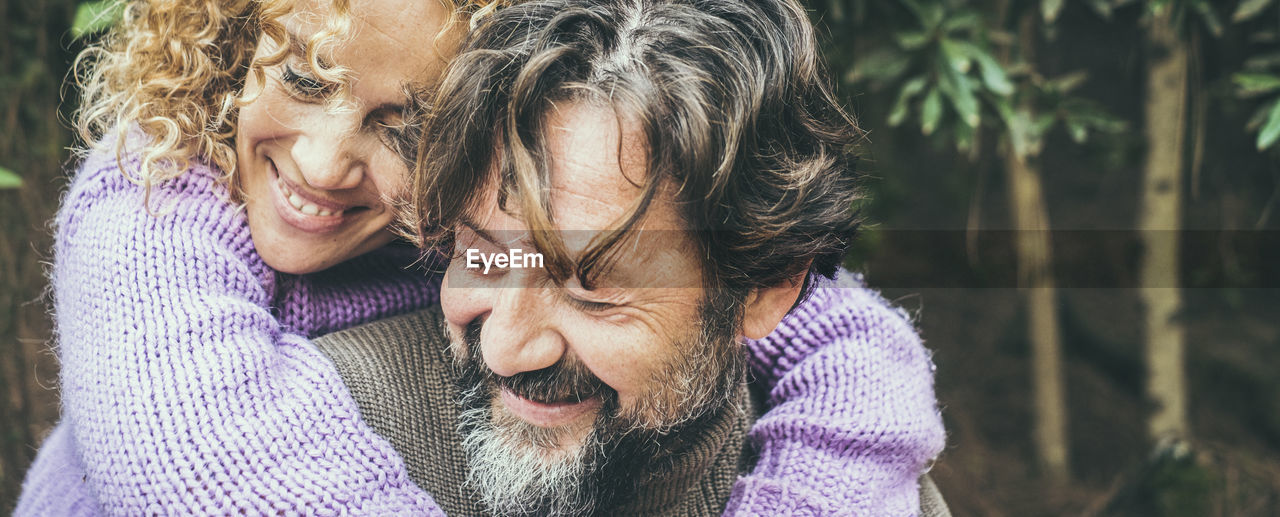 Smiling couple embracing in forest