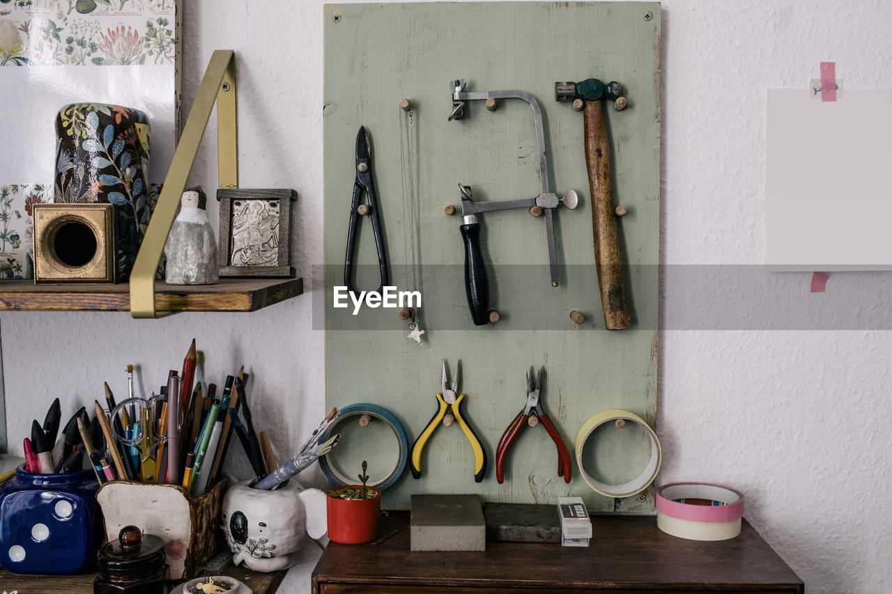 Work tools and equipment hanging on board by wall