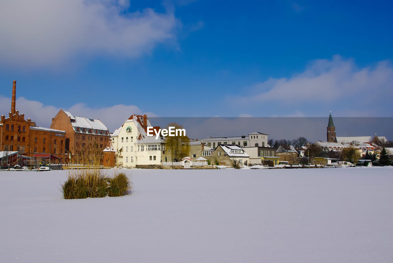 View of houses in town against cloudy sky