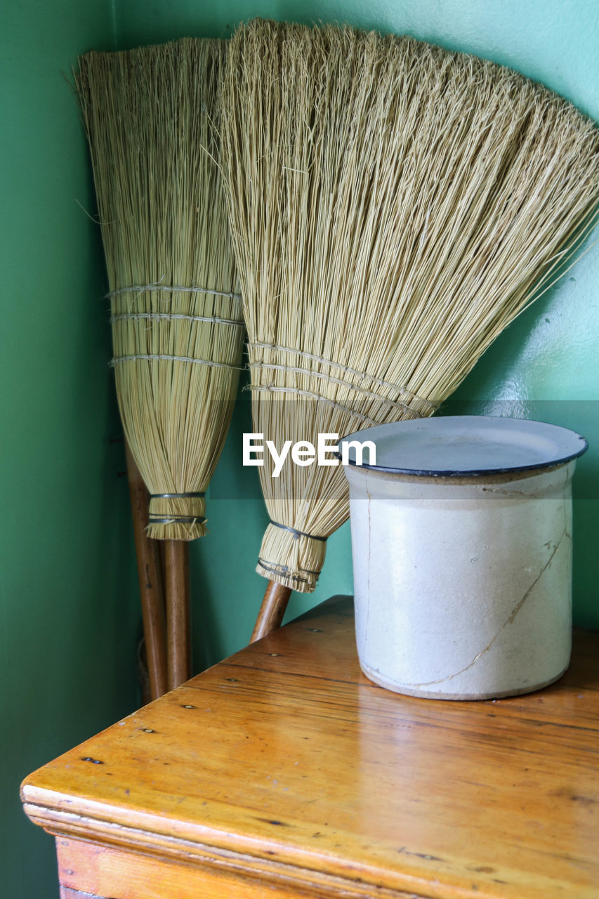 Containers and broom on table at home