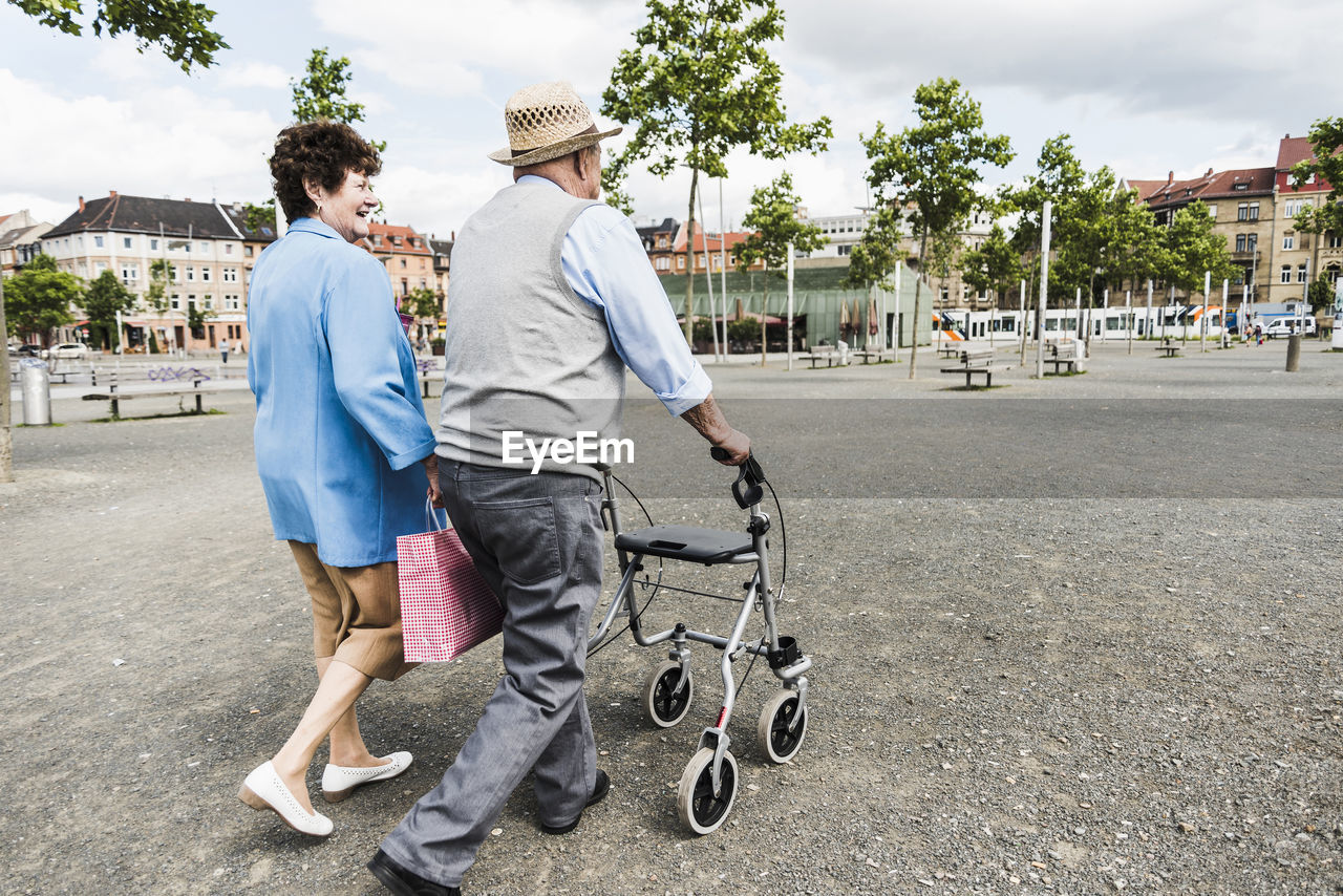 Germany, mannheim, back view of senior couple with wheeled walker