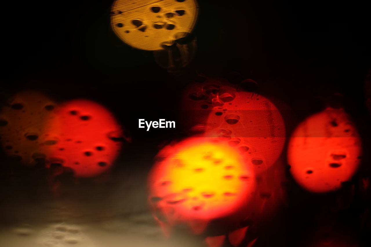 CLOSE-UP OF WATER DROPS ON ILLUMINATED GLASS