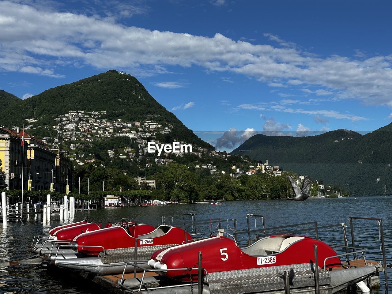 mountain, water, sky, transportation, nature, mountain range, architecture, cloud, vehicle, nautical vessel, sea, mode of transportation, no people, scenics - nature, boat, travel destinations, day, vacation, travel, beauty in nature, built structure, building exterior, ship, moored, building, outdoors, tree, watercraft, city, land, tourism, landscape, boating, tranquility