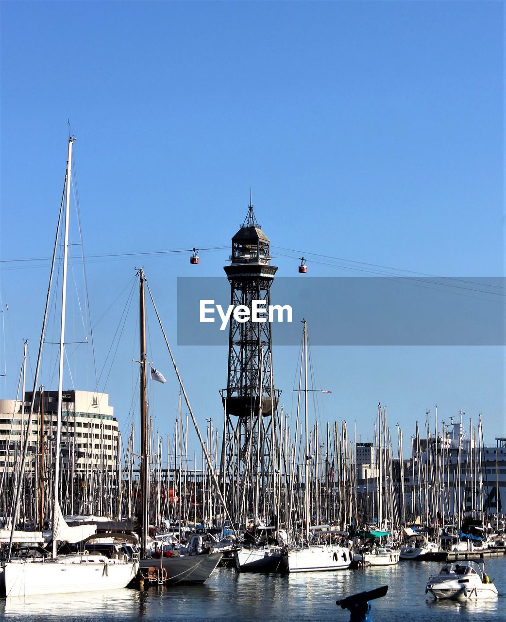 Boats in sea against clear blue sky