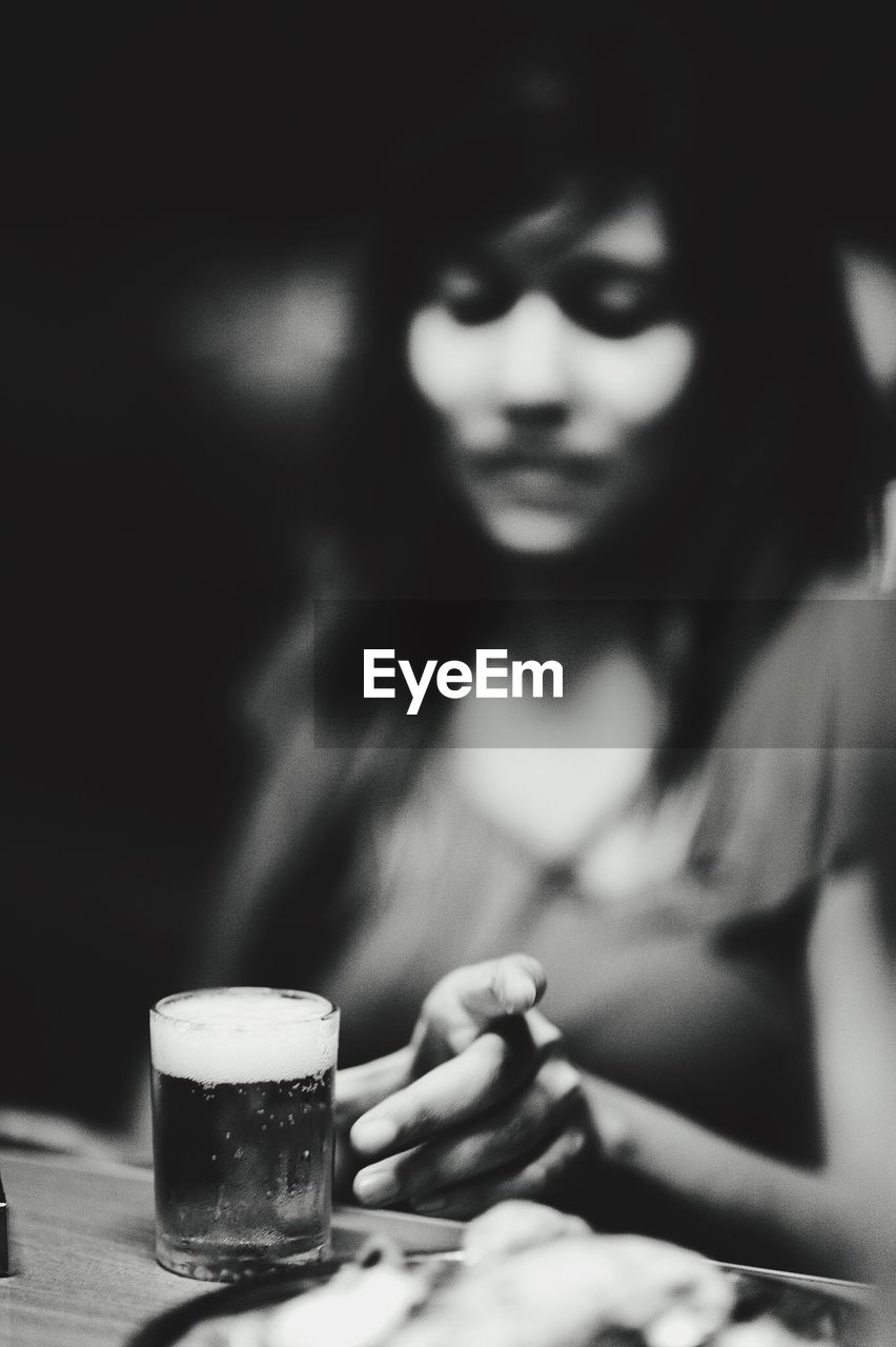 Defocused image of woman drinking beer in restaurant