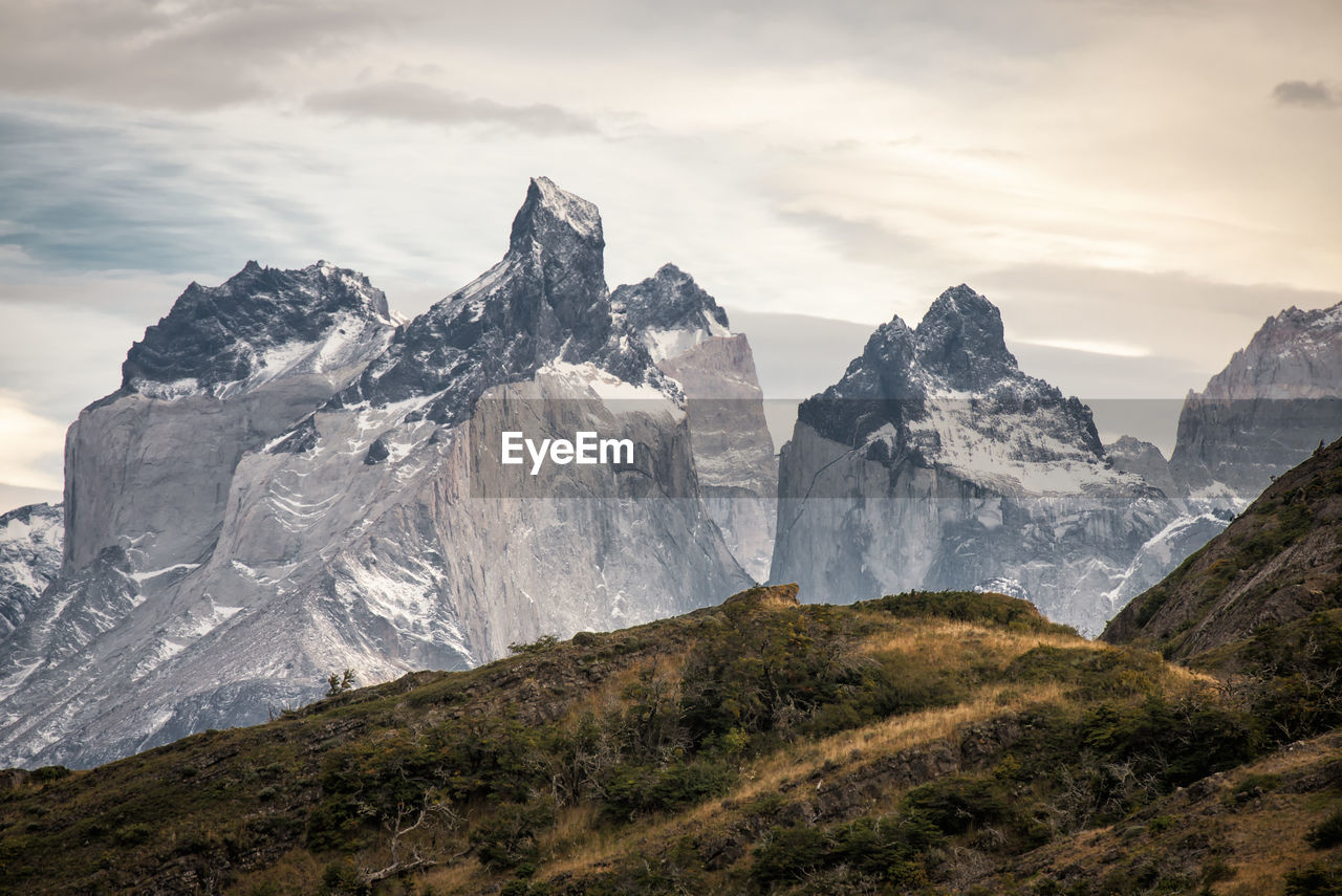 Scenic view of mountains against cloudy sky