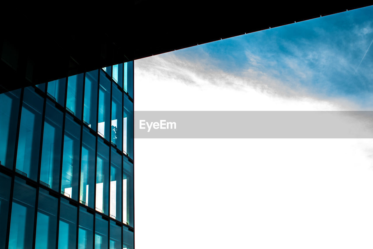 DIRECTLY BELOW SHOT OF GLASS BUILDING AGAINST SKY