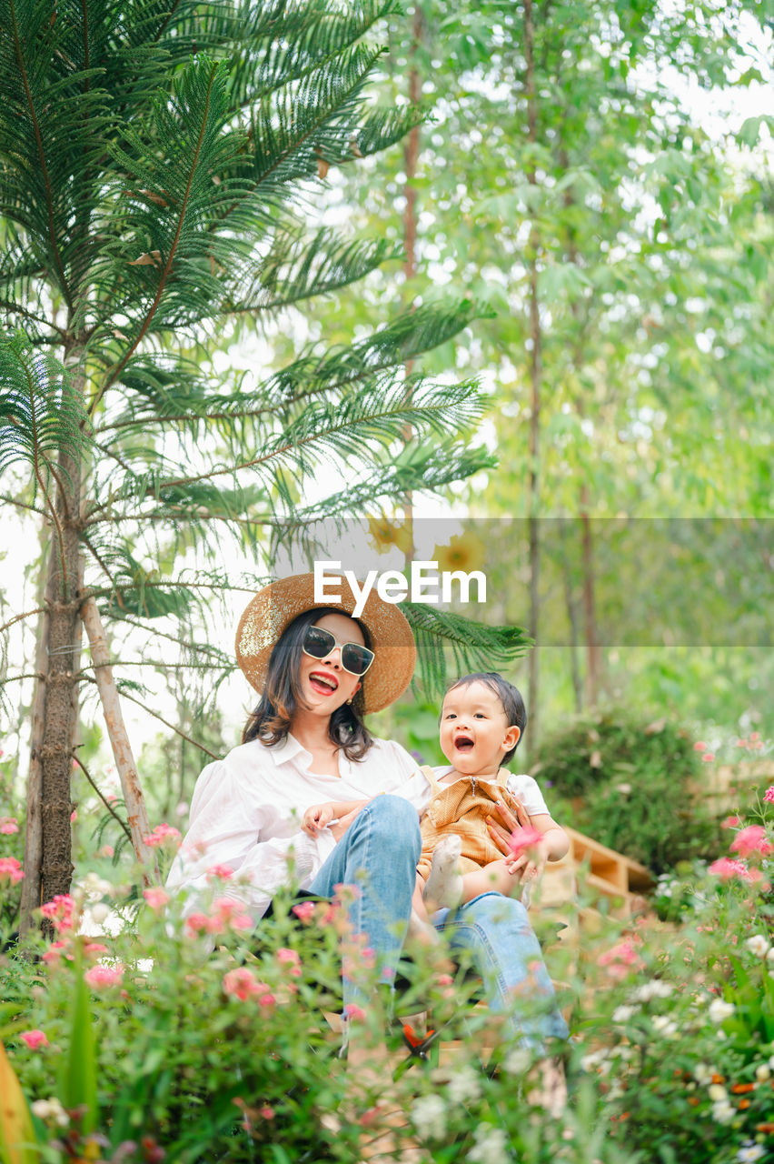 Mother and son sitting at forest during autumn