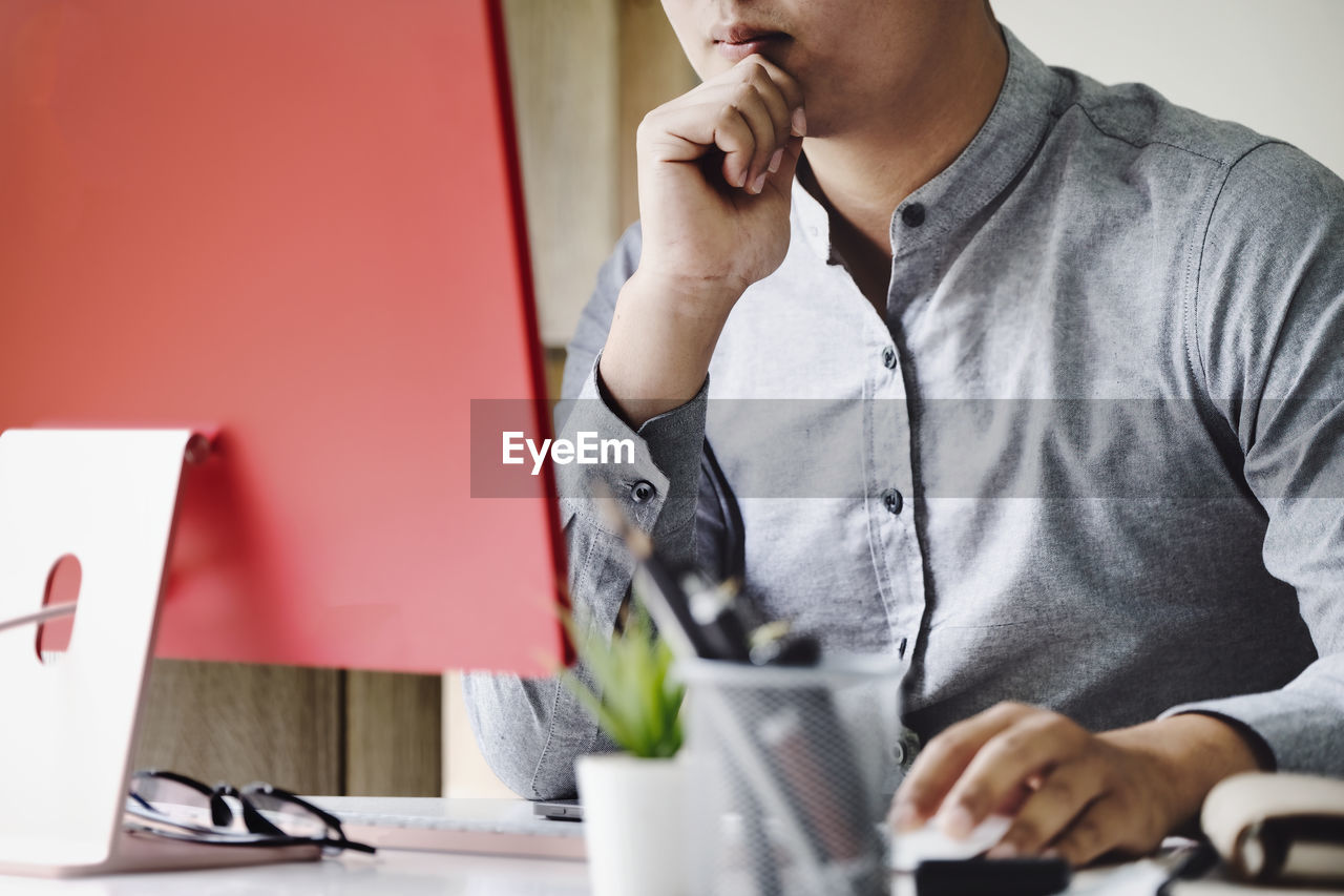 Midsection of man using laptop on table