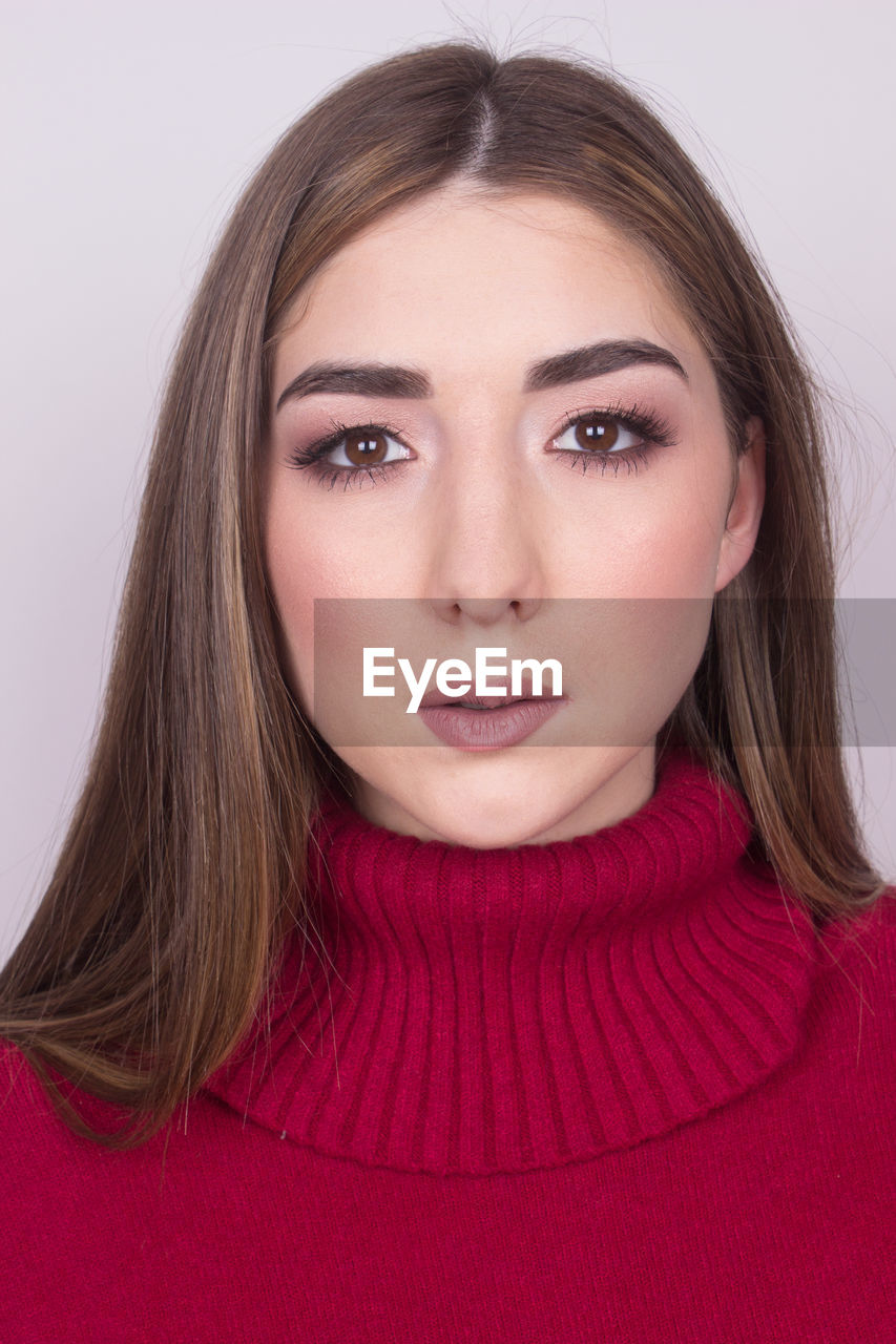 Portrait of young woman against purple background