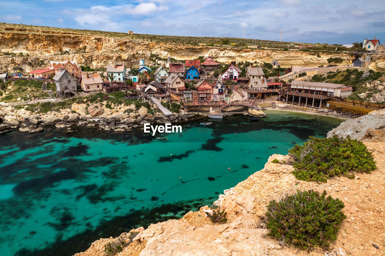 High angle view of buildings by sea against sky