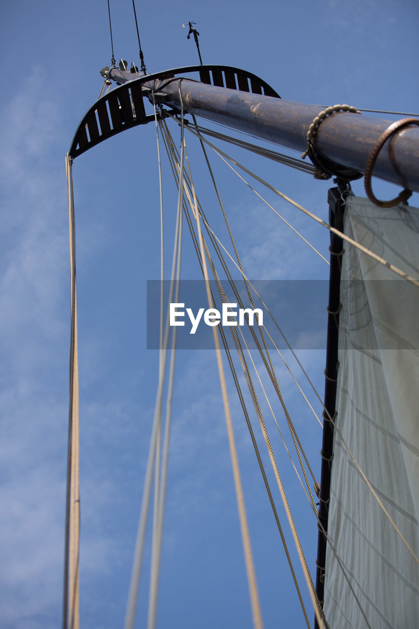 Low angle view of sailboat against blue sky