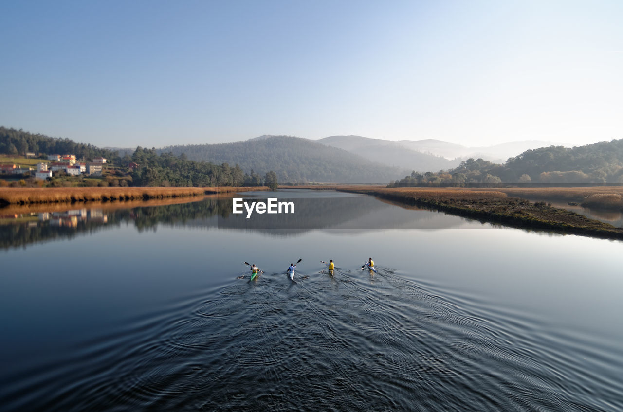 People in lake against sky