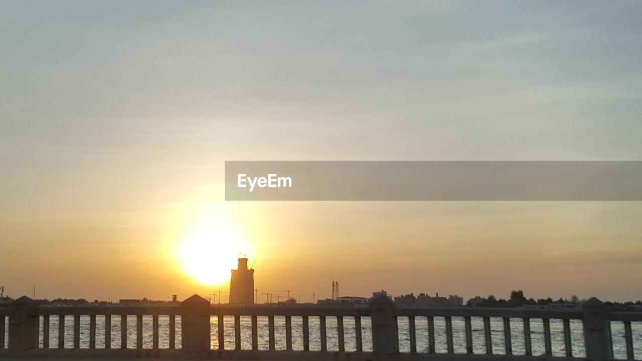 SILHOUETTE BUILT STRUCTURE AGAINST SKY AT SUNSET