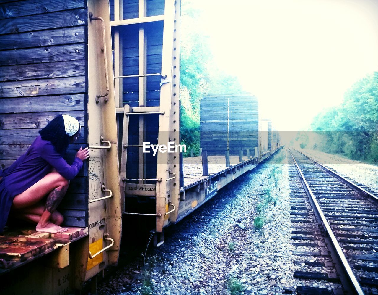 Woman crouching on railroad car