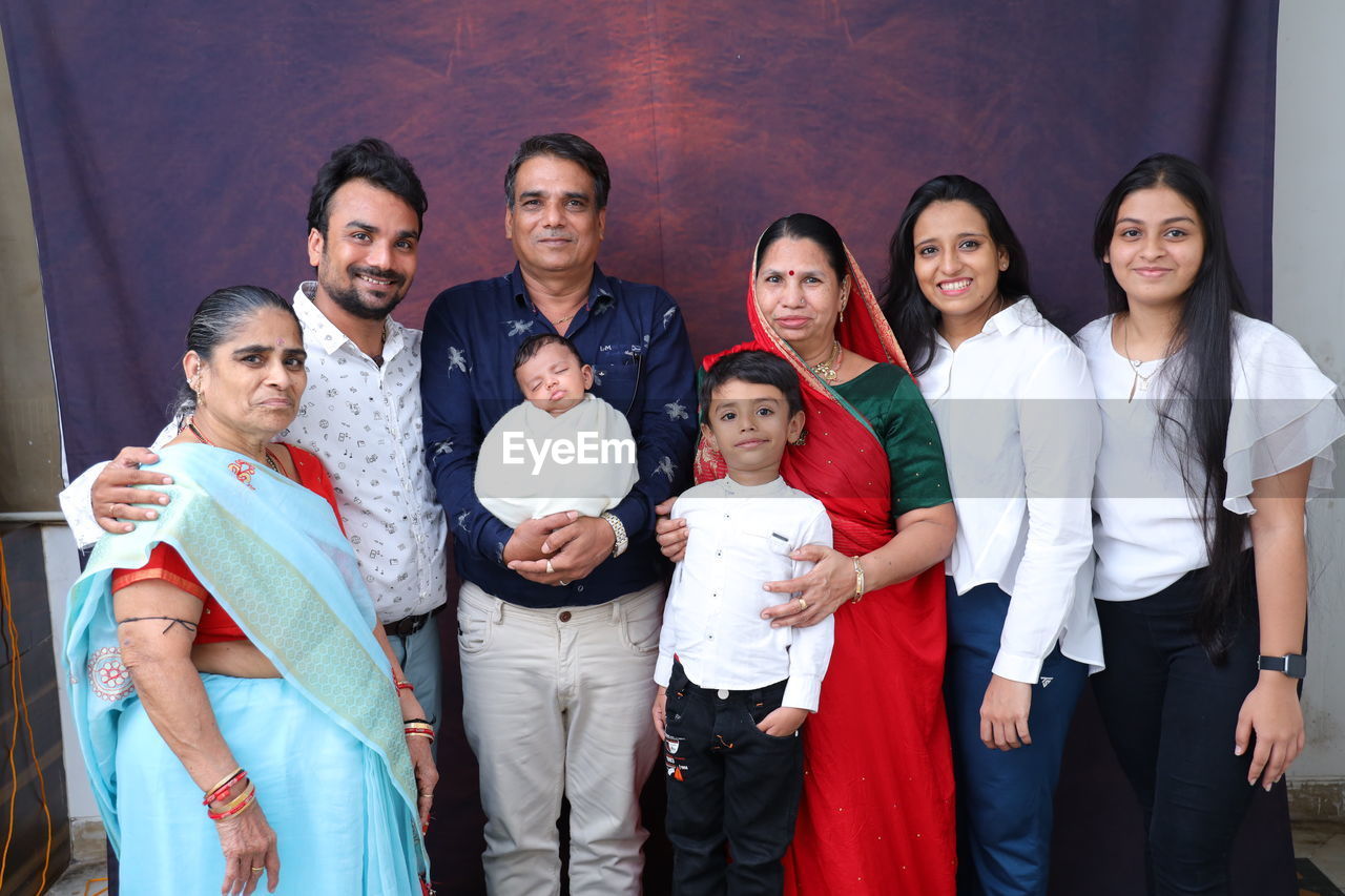 group of people, men, women, adult, smiling, female, child, happiness, togetherness, social group, emotion, childhood, young adult, portrait, looking at camera, ceremony, group, family, marriage, parent, standing, medium group of people, positive emotion, cheerful, person, mature adult, father, indoors, clothing, love, business, wedding, human face, lifestyles, friendship
