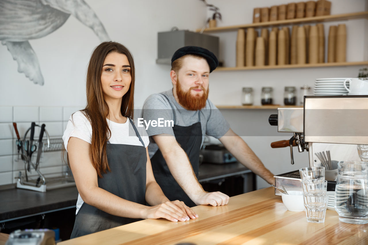 portrait of smiling friends sitting on table