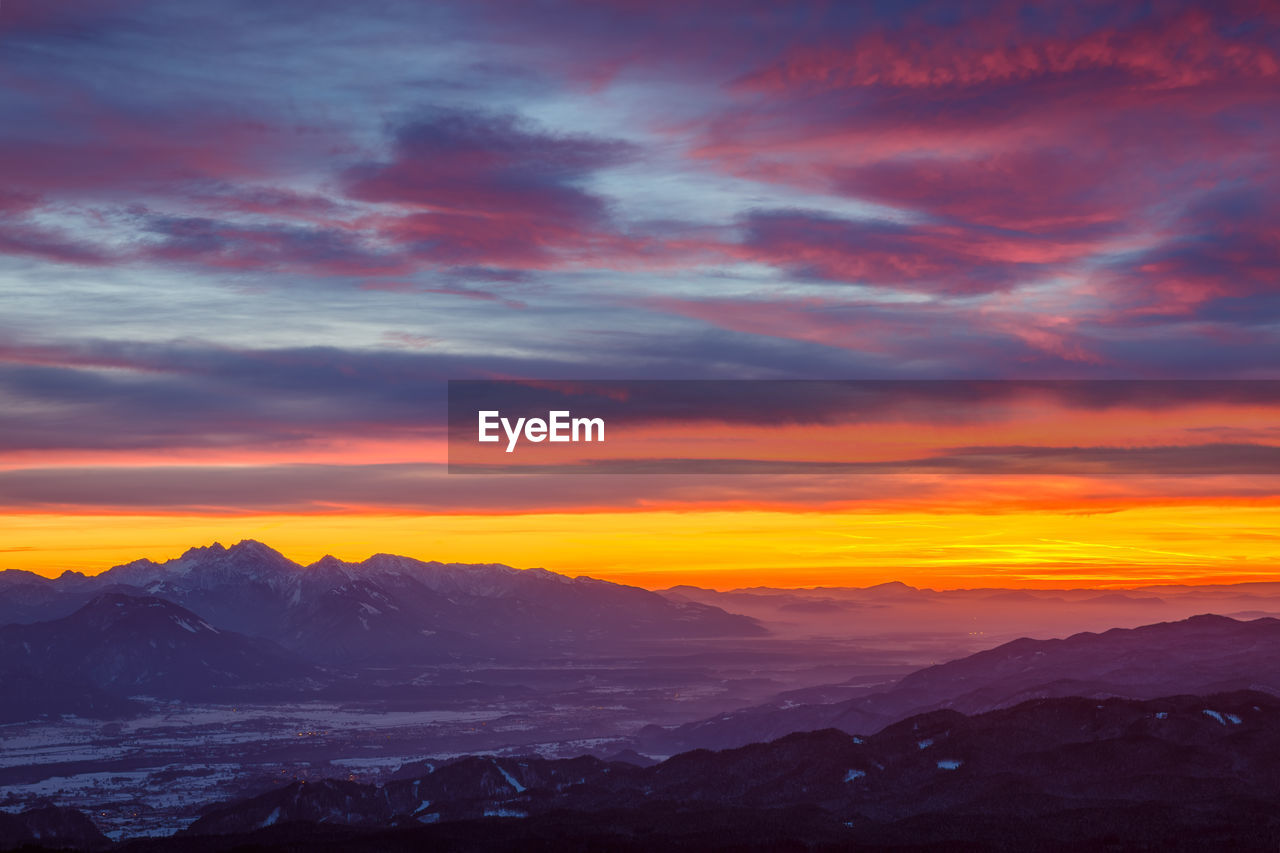 Scenic view of snowcapped mountains against dramatic sky