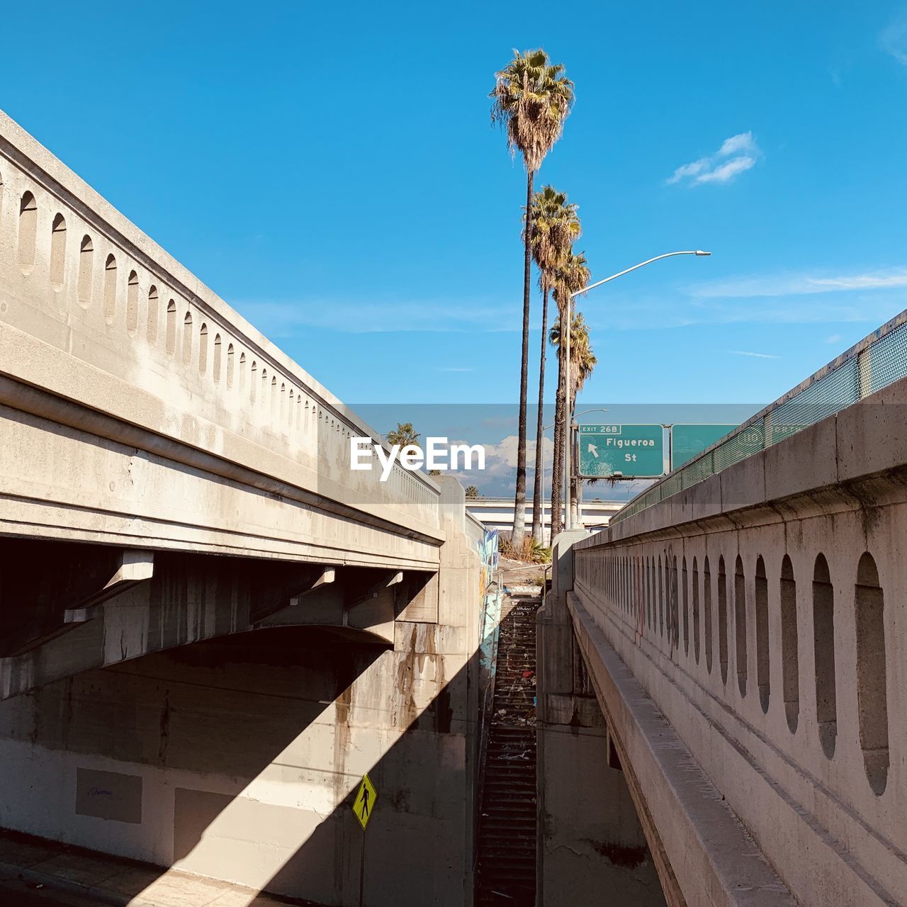 Low angle view of bridge in city against sky