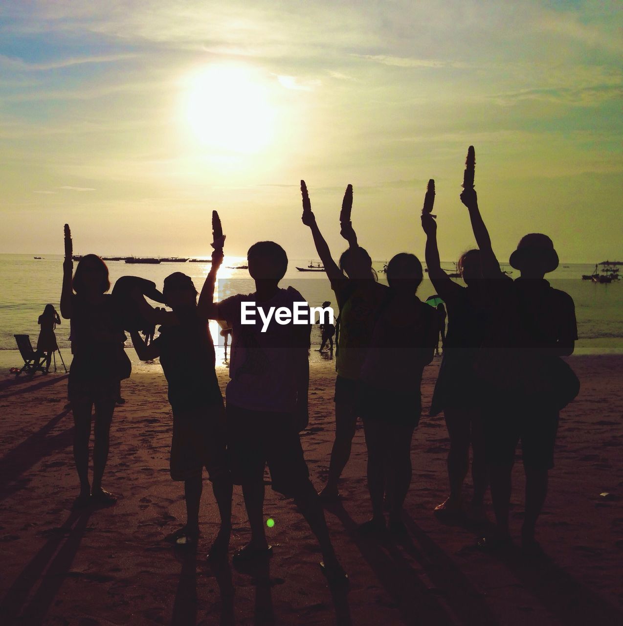 Group of silhouette children standing on beach