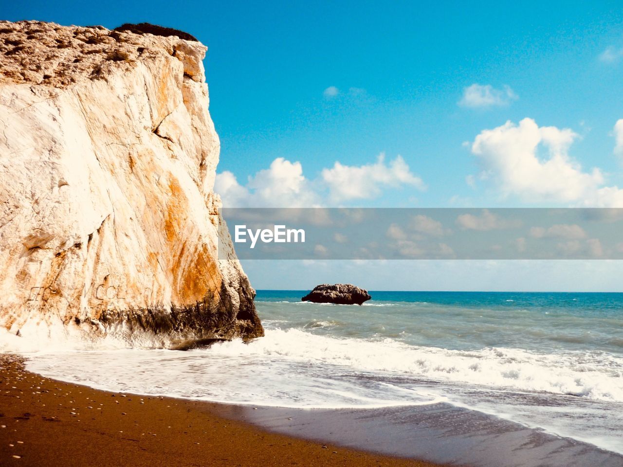 Rock formation on beach against sky