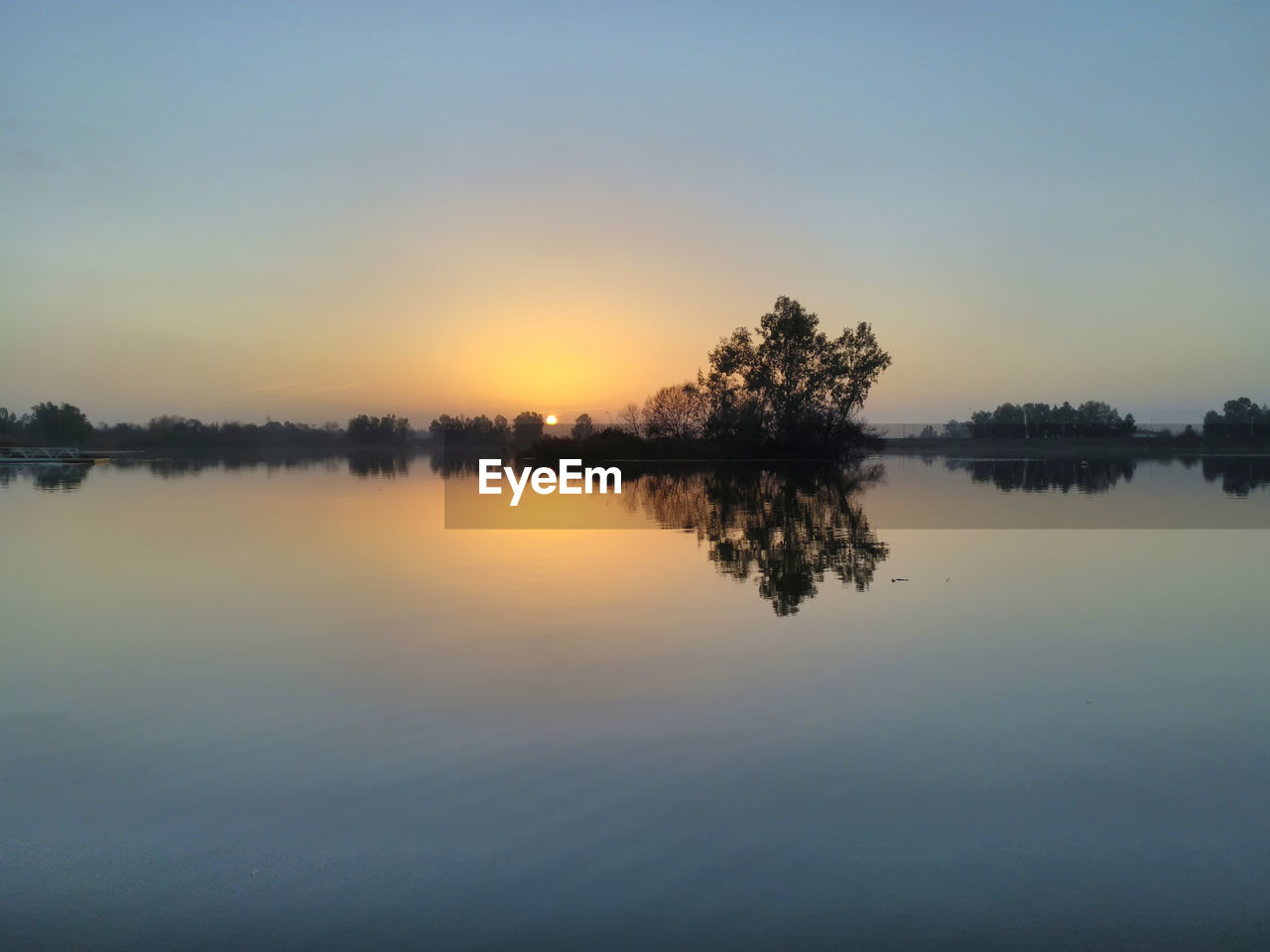 Scenic view of lake against sky at sunset