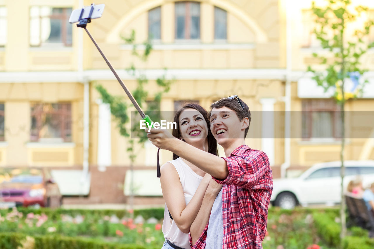 Young couple smiling in front of building