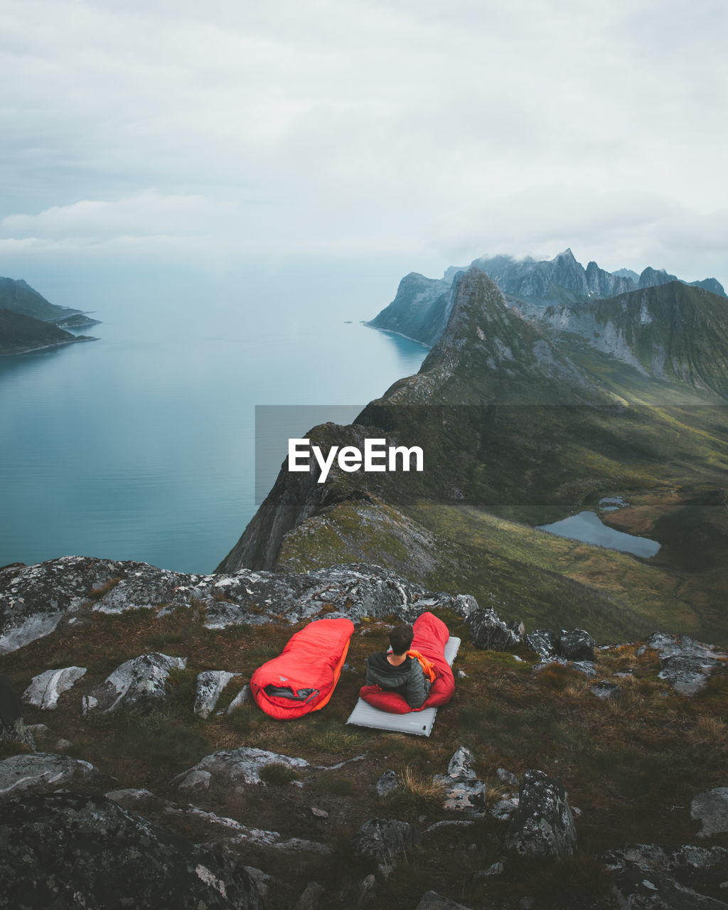 Man lying on mountain against sea