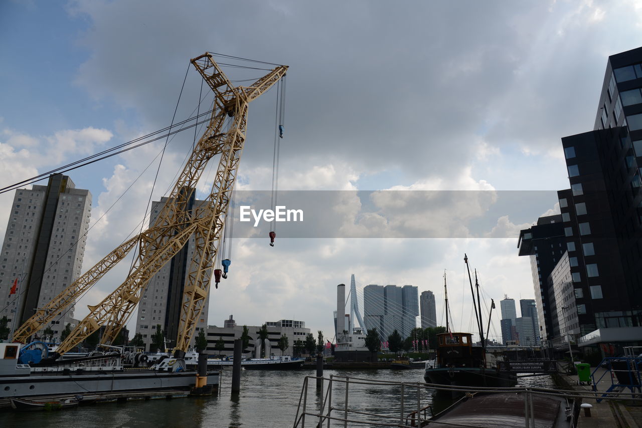SAILBOATS IN CITY AGAINST SKY