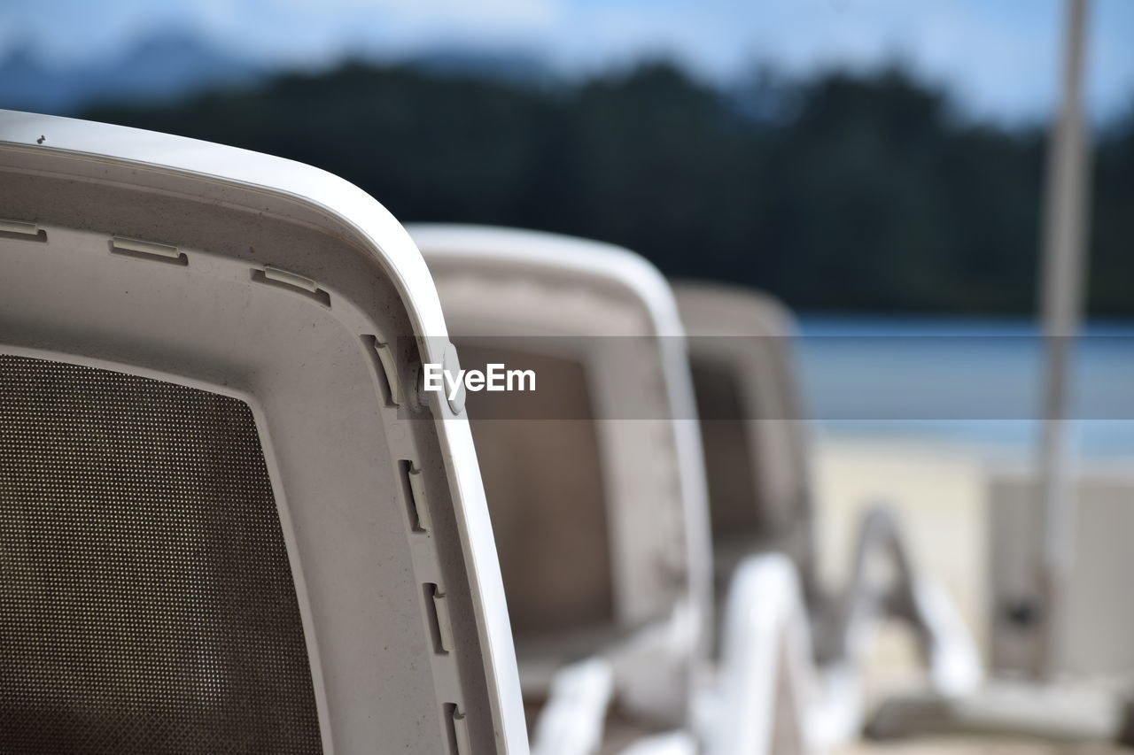 Close-up of empty chairs at beach