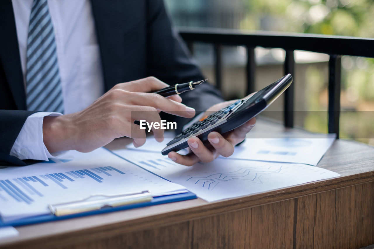 midsection of business colleagues working on table