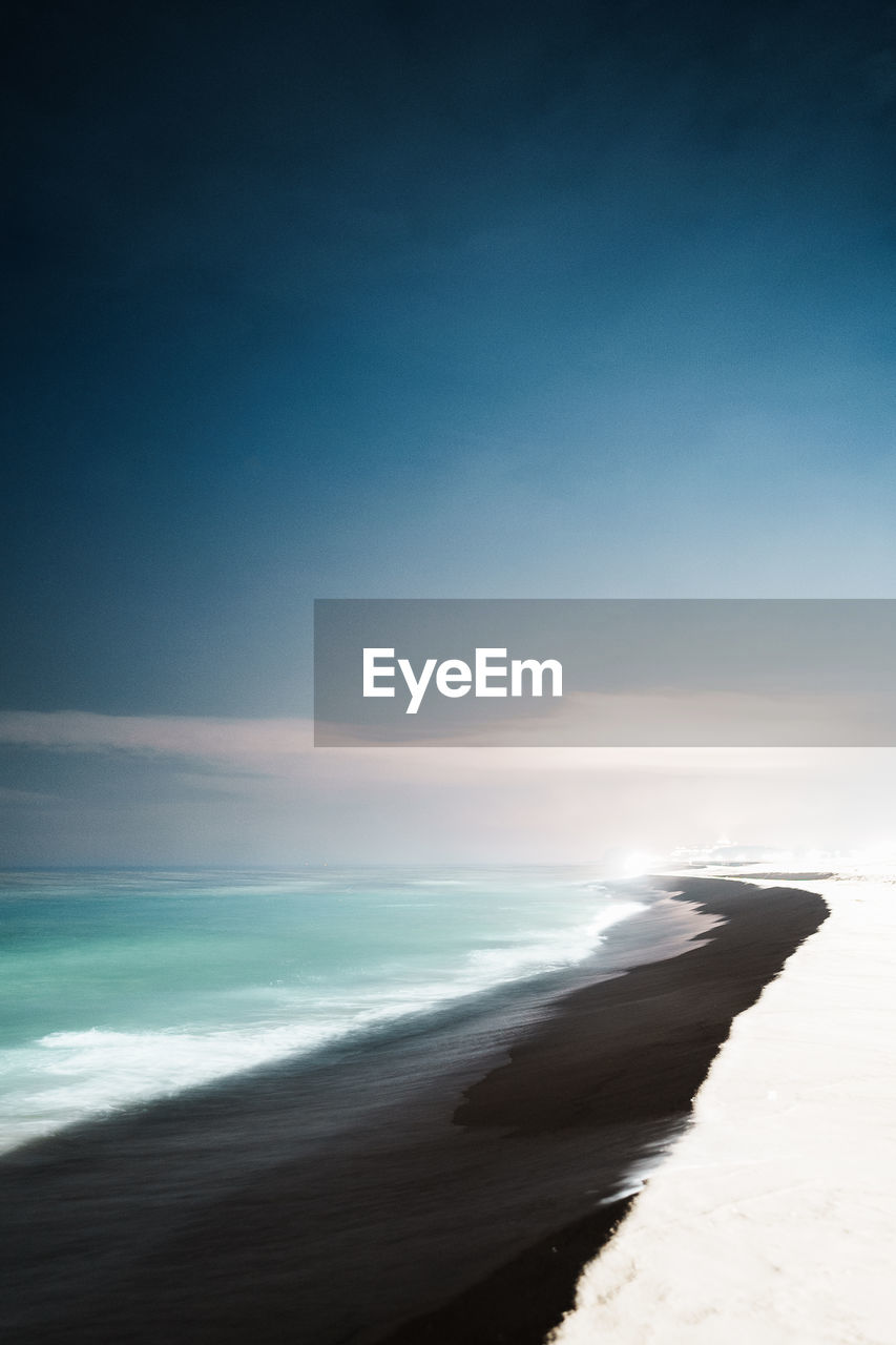 scenic view of beach against sky at sunset